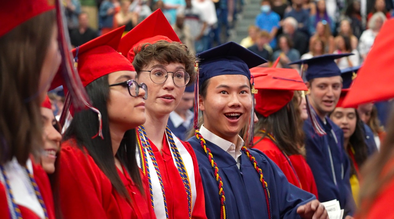 An LHS student smiles while standing with his peers at the 2022 graduation ceremony.